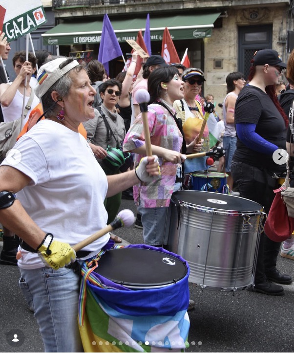A group of people walking along a city street, part of a protest march.