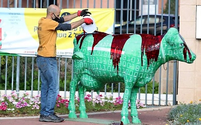 A man pours blood over a statue of a cow